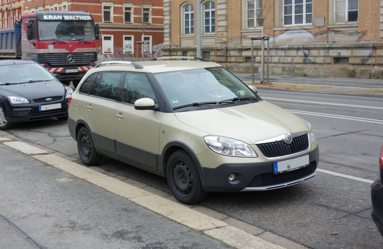 Compact wagon with rugged black cladding, roof rails, and front-side view
