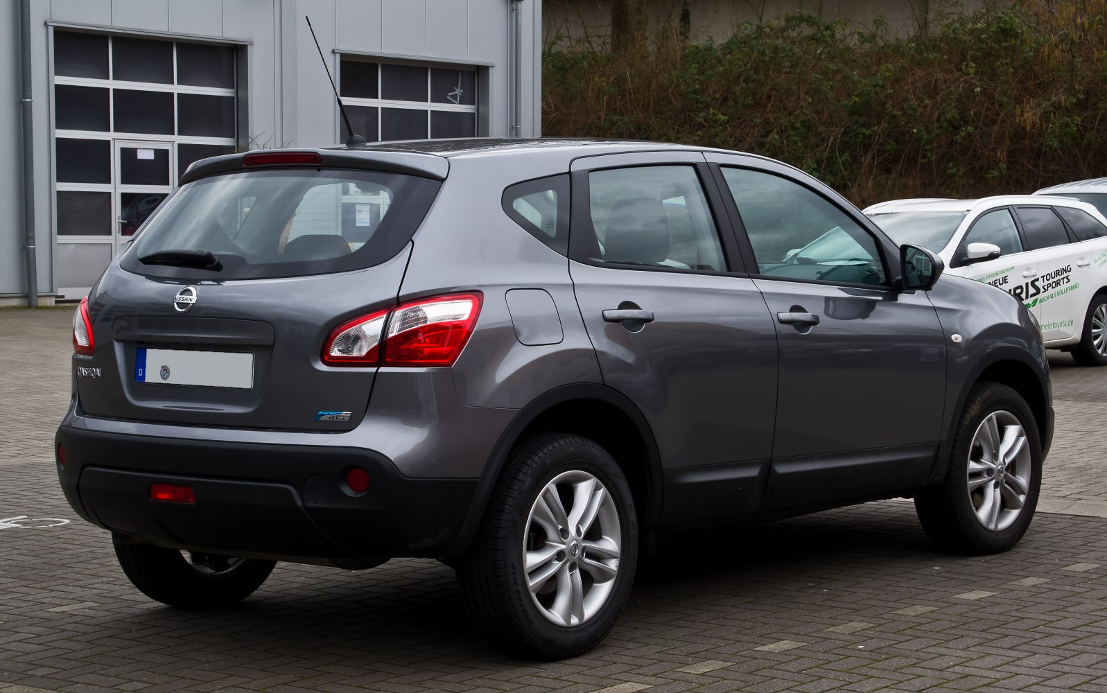 Rear side view of gray compact SUV with distinctive rear lights and five-door body.