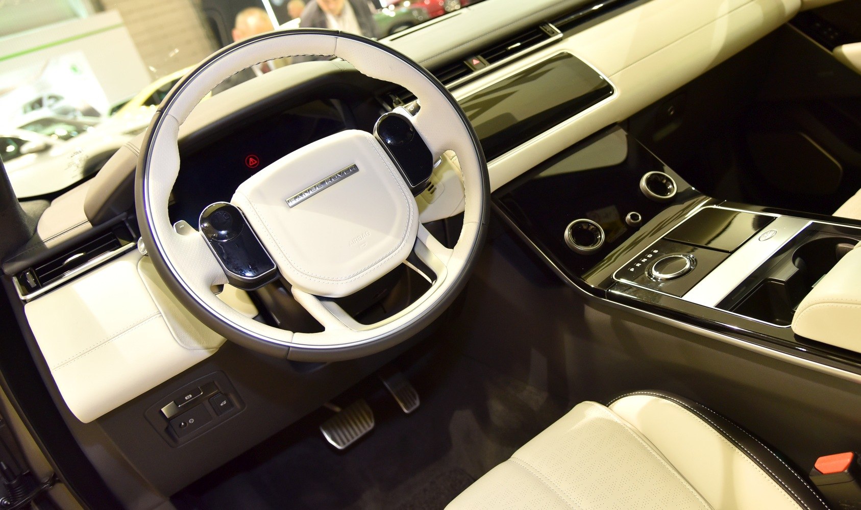 Sporty steering wheel and sleek center console with controls in a modern SUV interior