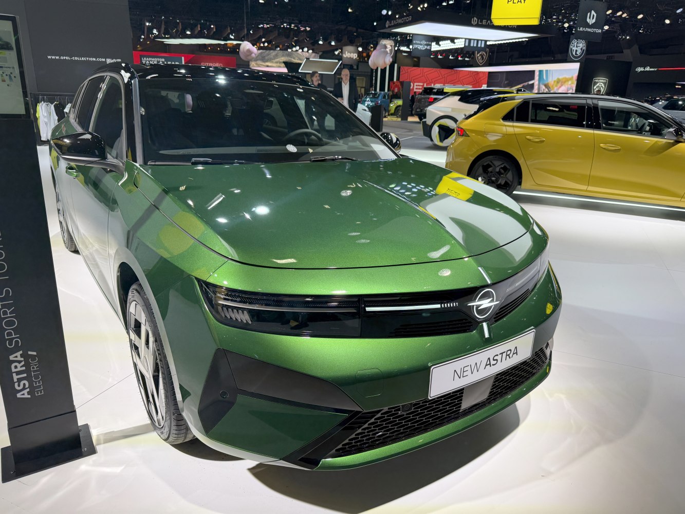 Green metallic car front with sleek headlights and a modern grille design