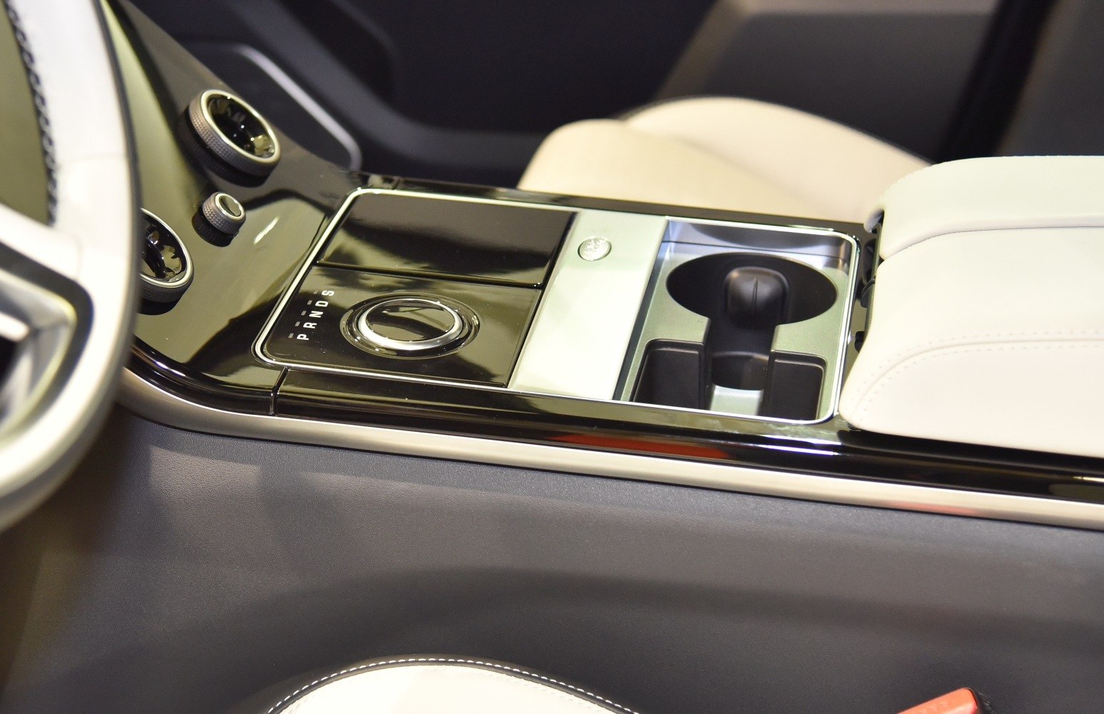 Rotary gear selector and dual cup holders in luxury SUV center console