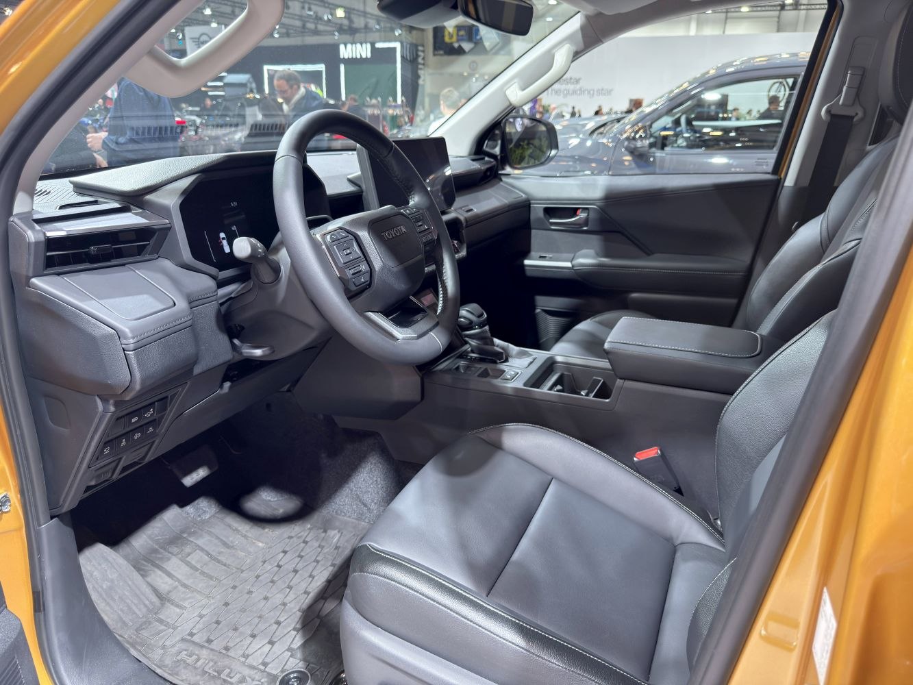Modern dashboard, steering wheel, and front seats of a pickup interior