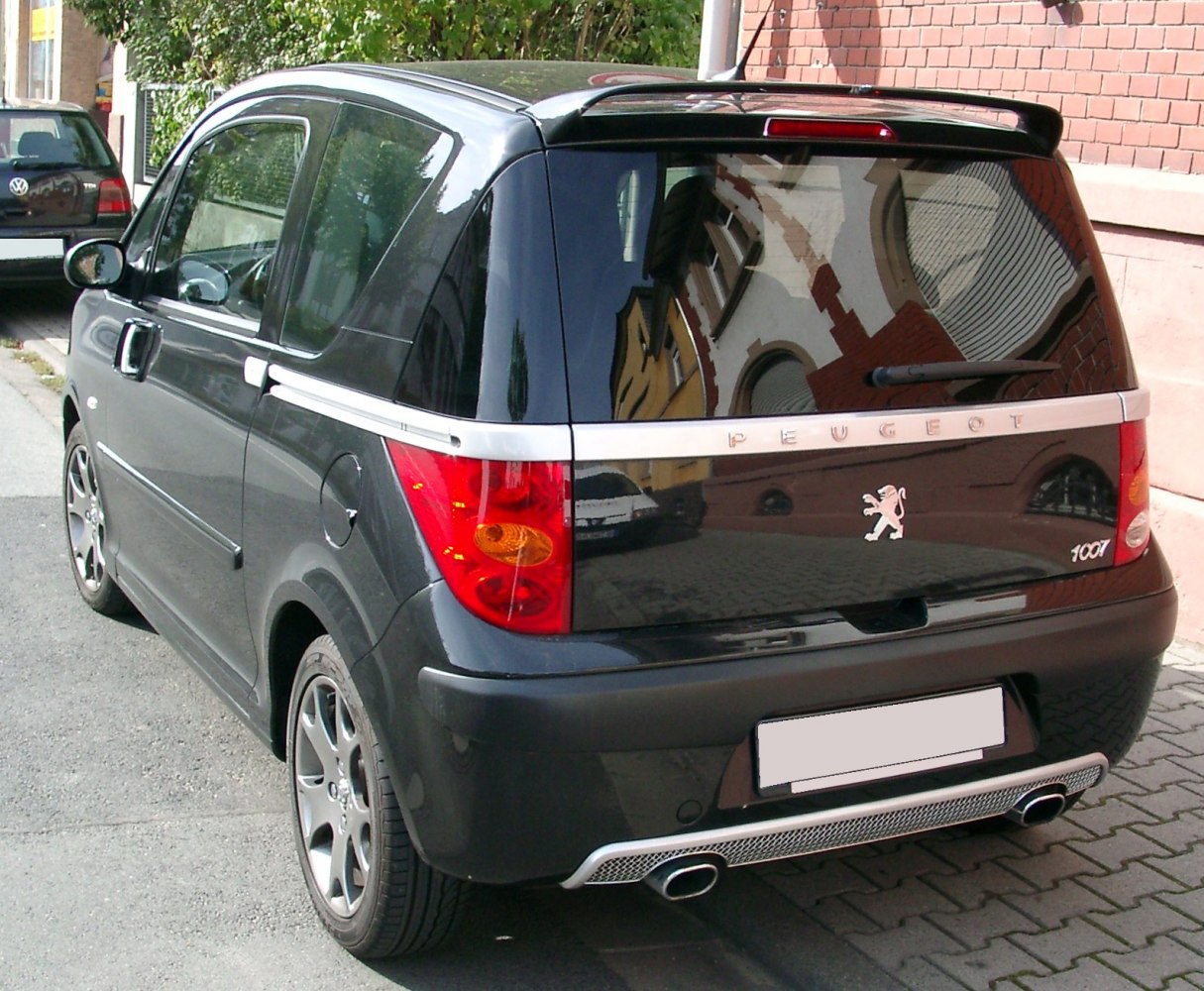 Rear side view highlighting sliding door and sporty exhaust design.