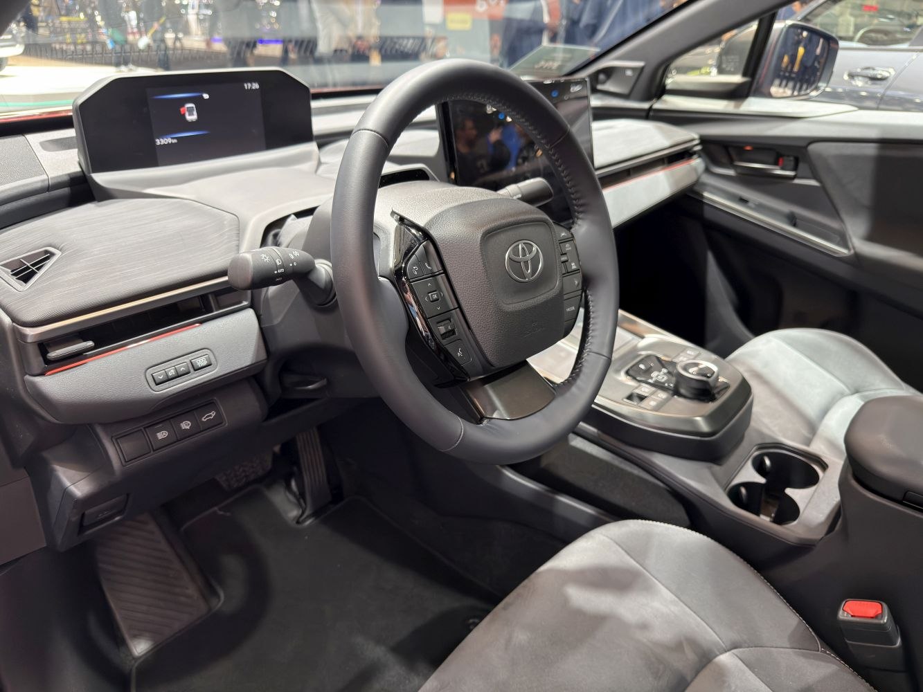 Steering wheel with integrated controls and dual digital display screens.