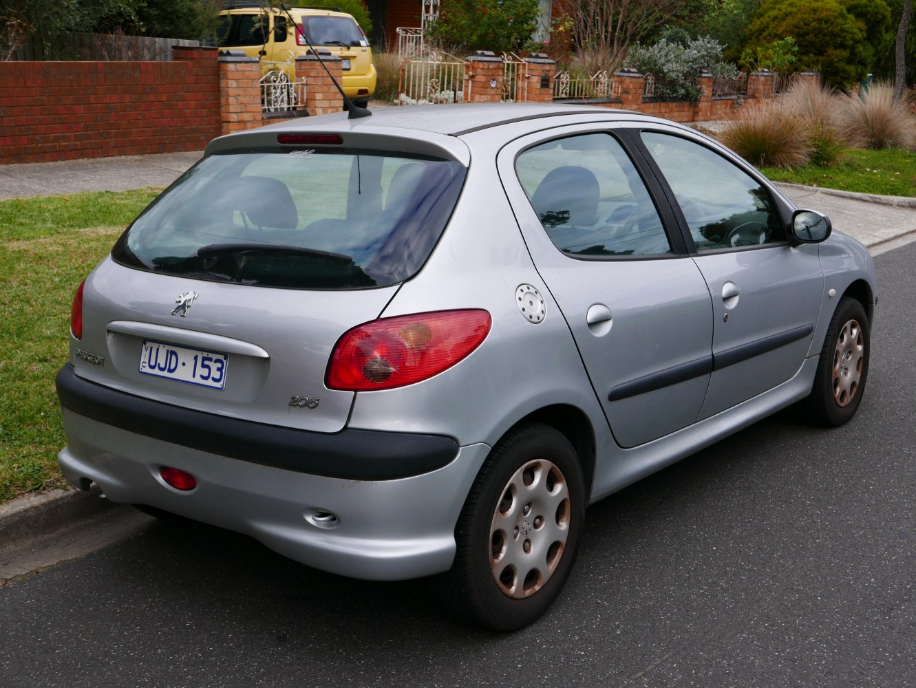 Silver hatchback rear and side view with black bumper and round fuel cap.