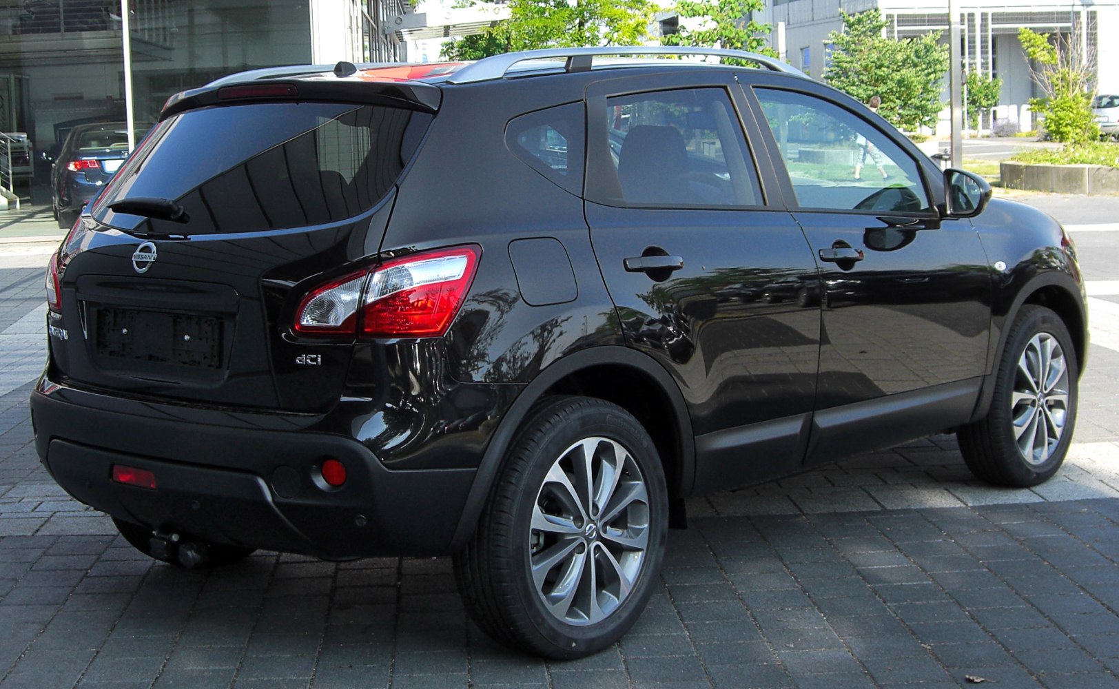 Rear side view of a black crossover SUV with tinted windows and chrome wheels.