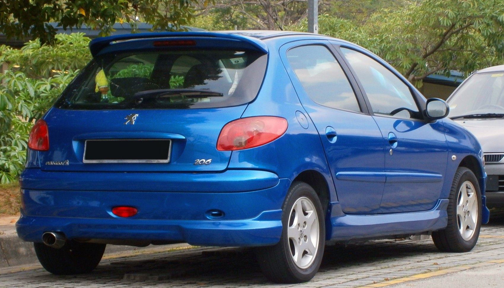 Rear view of blue subcompact hatchback with spoiler and alloy wheels