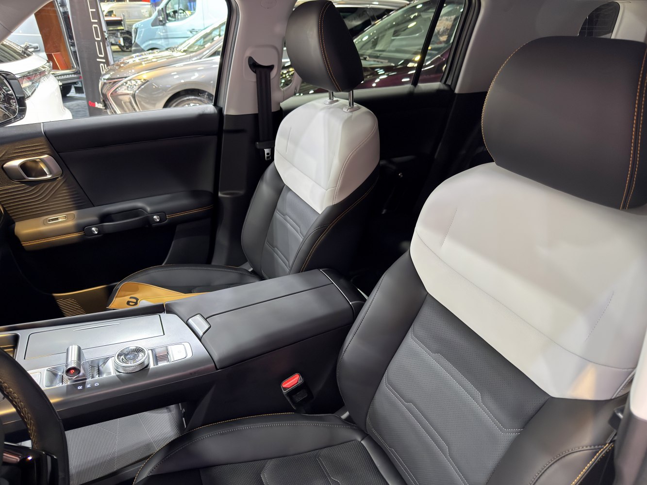 Black and white leather front seats with detailed stitching and center console.