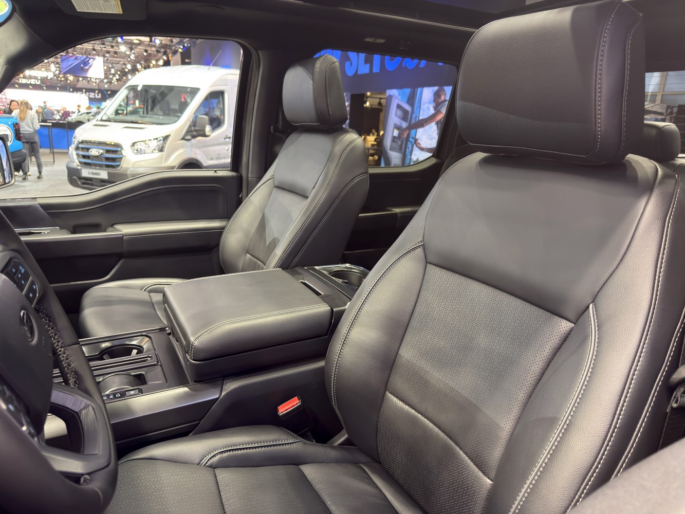 Leather front seats and spacious center console in truck interior.