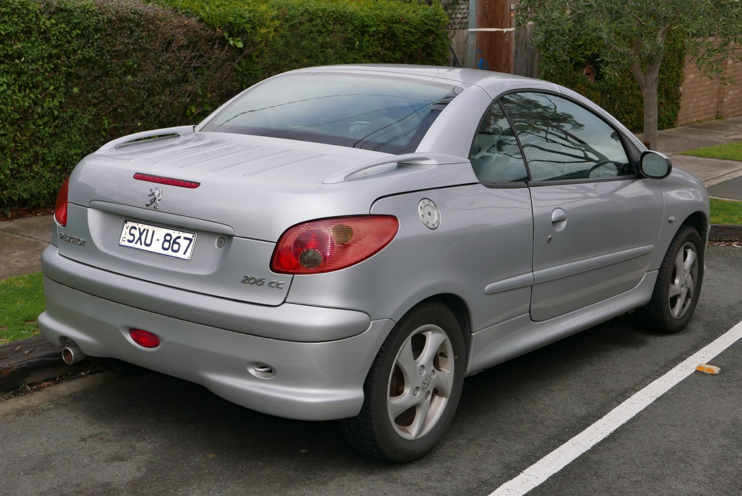 Rear and side view of silver convertible coupe with spoiler and tail lights