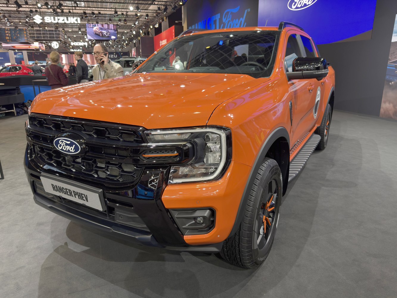 Front view of an orange PHEV pickup with LED headlights and black grille.