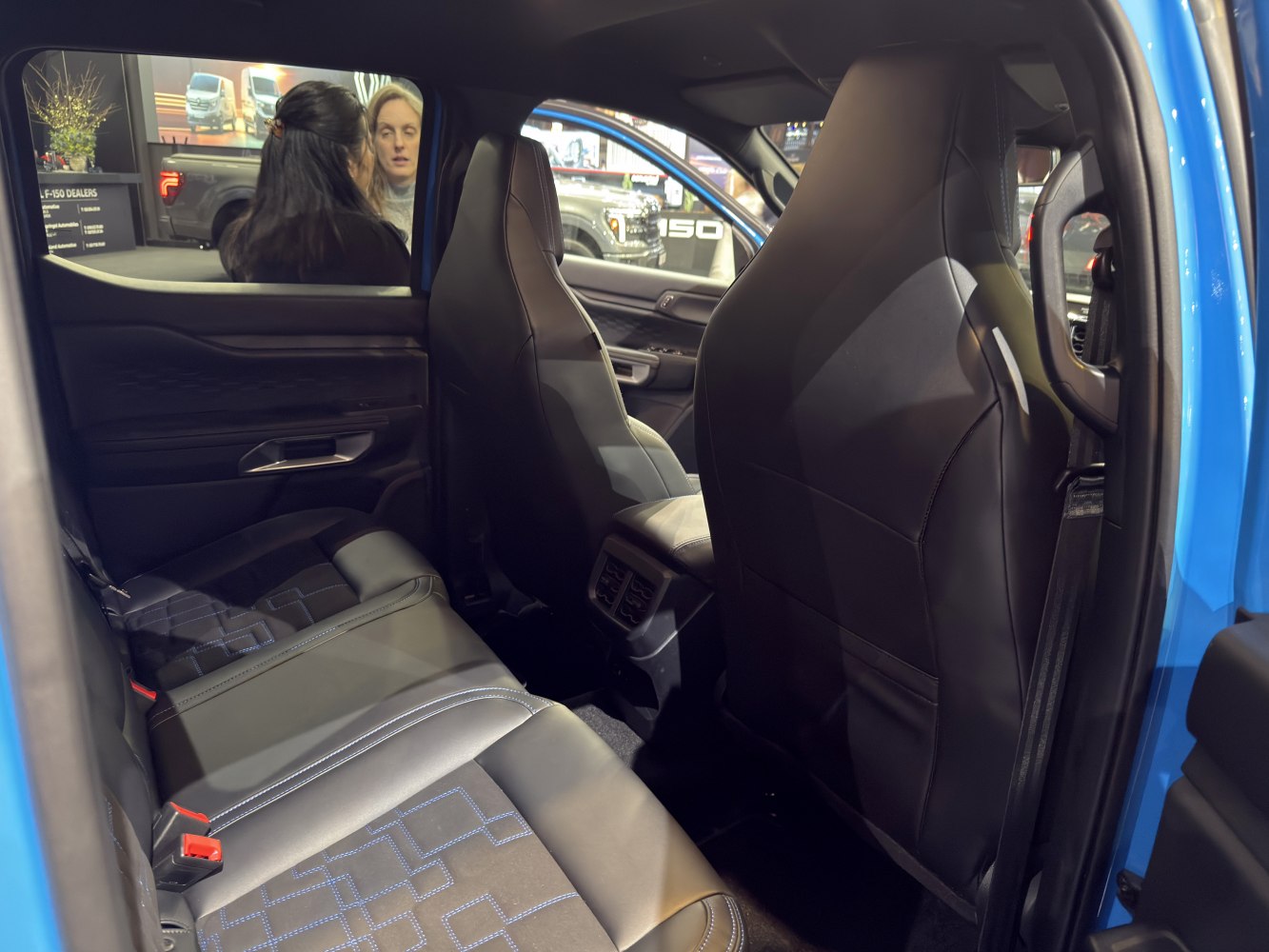 Spacious rear seating with black leather upholstery and detailed stitching.