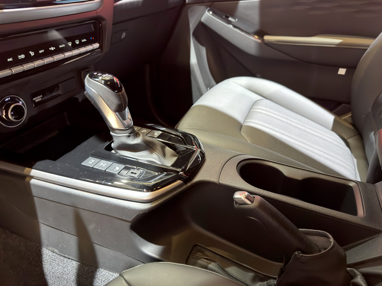 Gear shifter, control buttons, cup holder, and seat in double cab interior
