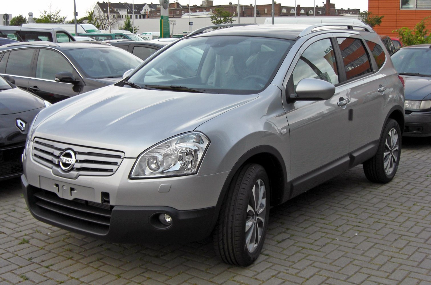 Front and side view of compact SUV with distinctive headlights and roof rails