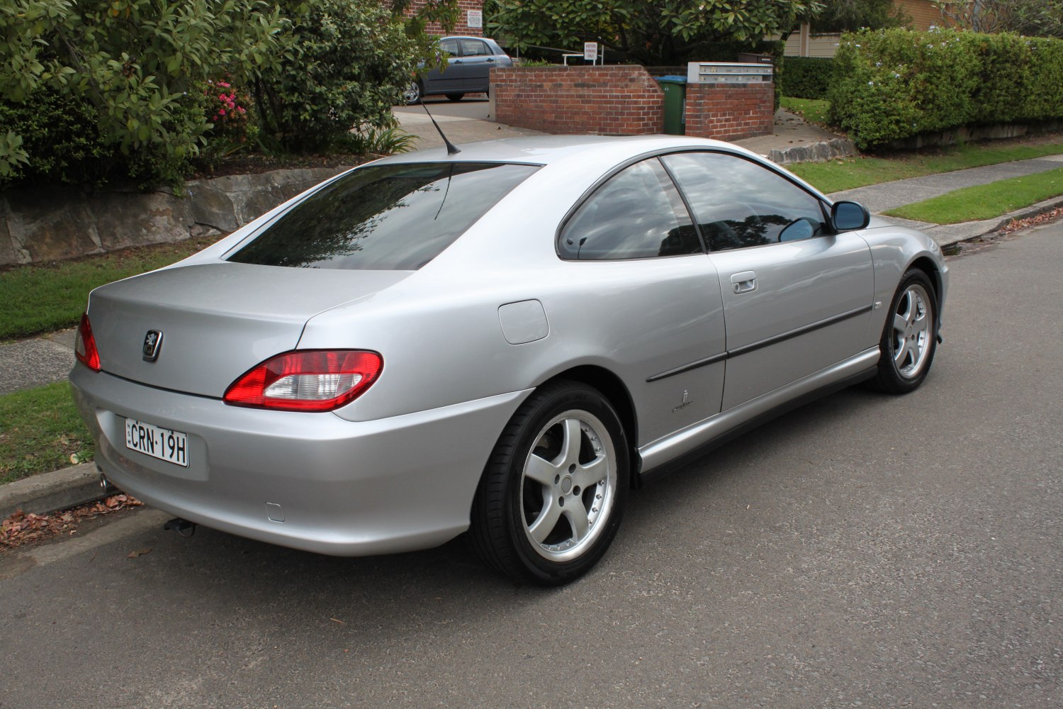 Rear side view of a sleek silver 2-door coupe with distinct taillights and alloy wheels.