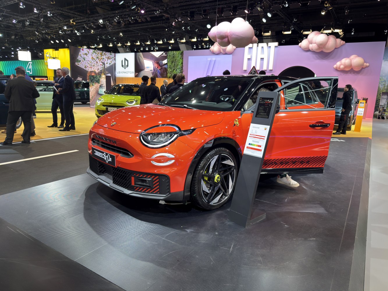 Electric compact car with LED headlights and sporty design in orange.