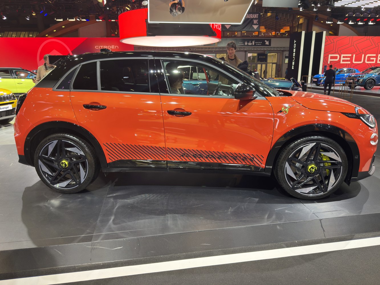 Electric compact SUV with two-tone orange and black paint, distinct alloy wheels and sporty decals.