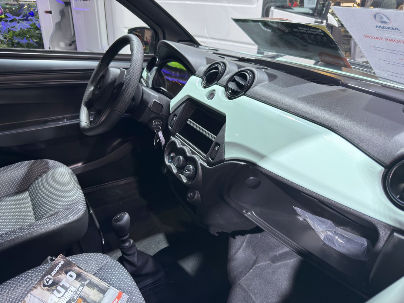 Compact interior with dashboard, round air vents, manual gear lever