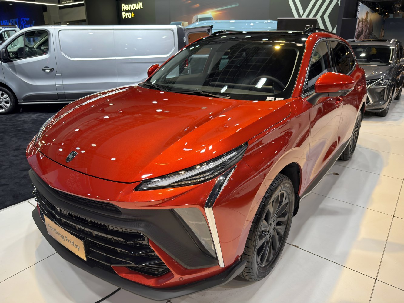 Front view of red vehicle with slim LED headlights and large grille