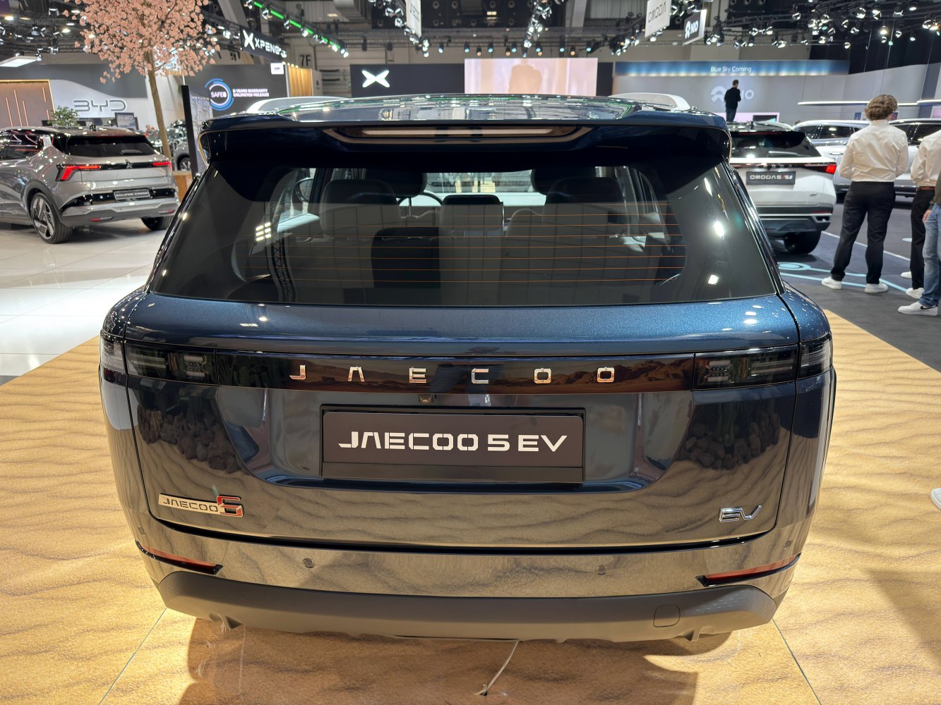 Rear view of an electric SUV with sleek tail lights and EV badge.