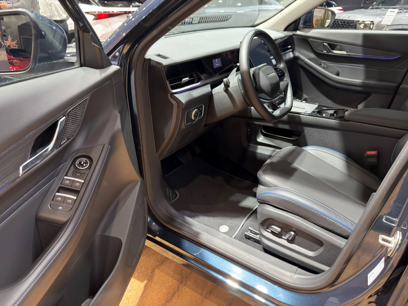 Driver side interior with steering wheel, controls, and power seat adjustments