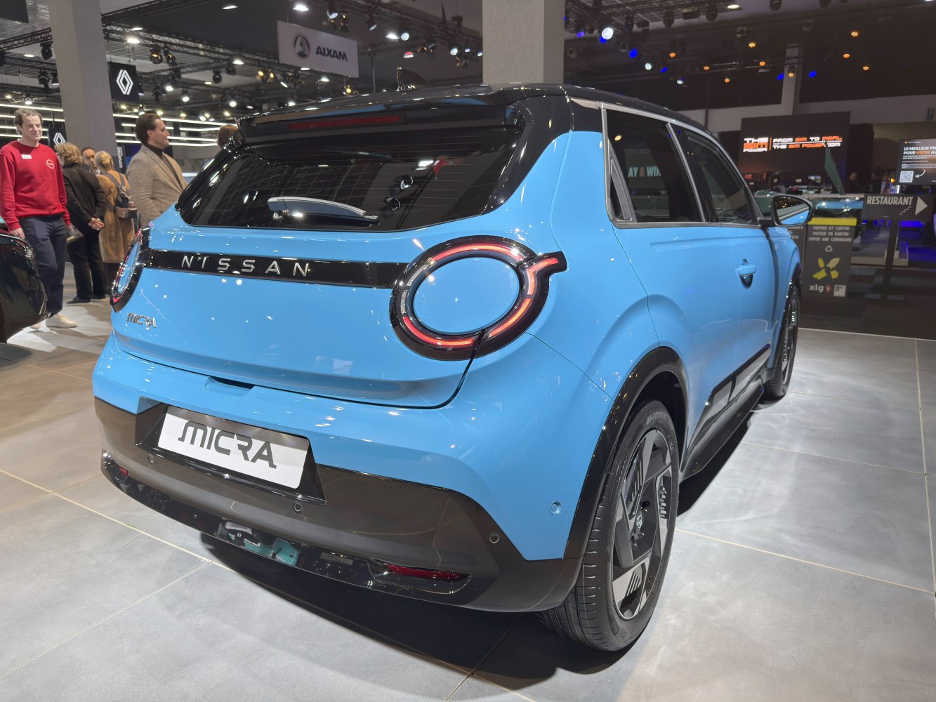Rear view of a modern hatchback with round tail lights and a blue body.