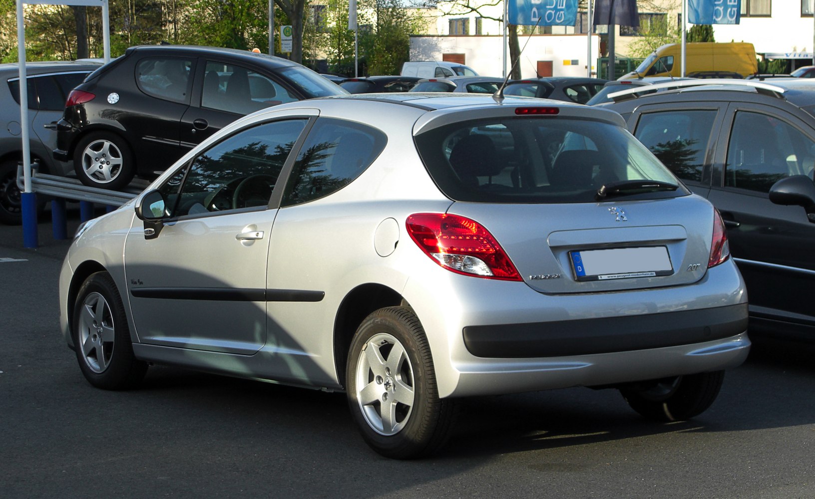 Rear side with taillights and alloy wheels in parking lot