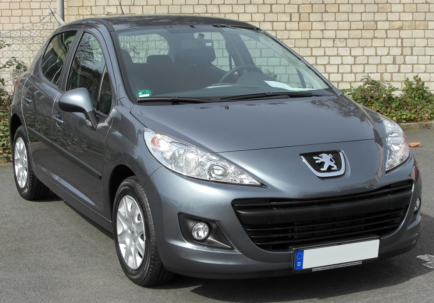 Front view of hatchback with headlights, grille, fog lights, alloy wheels
