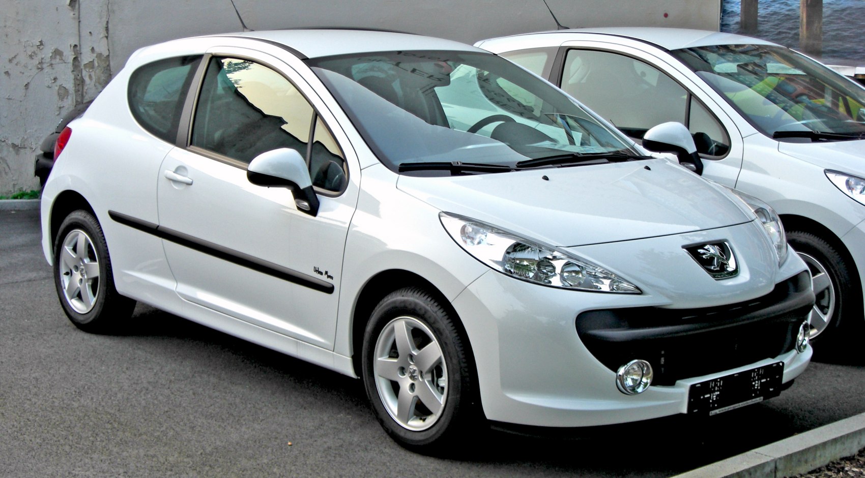 White compact hatchback with distinctive front headlights and alloy wheels