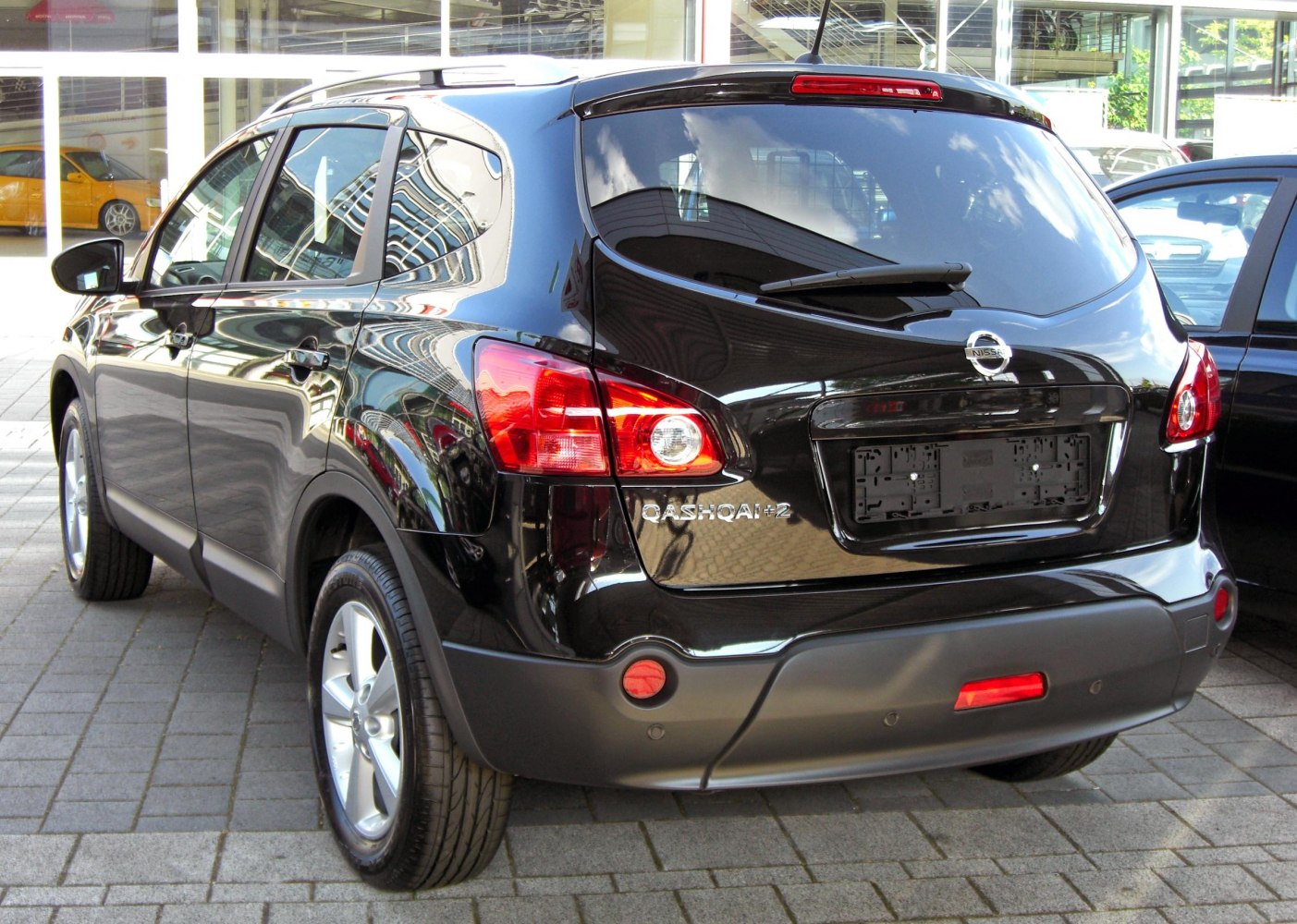 Rear view of black SUV highlighting tail lights and rear windshield wiper