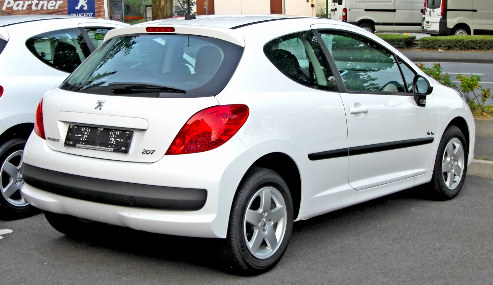 Rear view of white hatchback with red taillights and black bumper