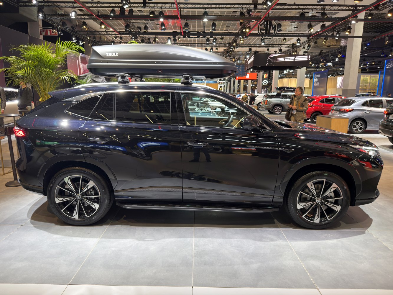 Side profile of a 2025 SUV with alloy wheels and Thule roof box