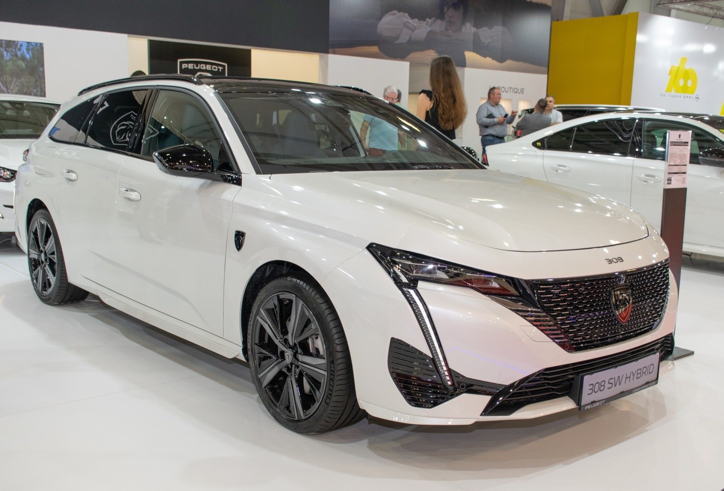 White hybrid estate car with sleek headlights and a black grille