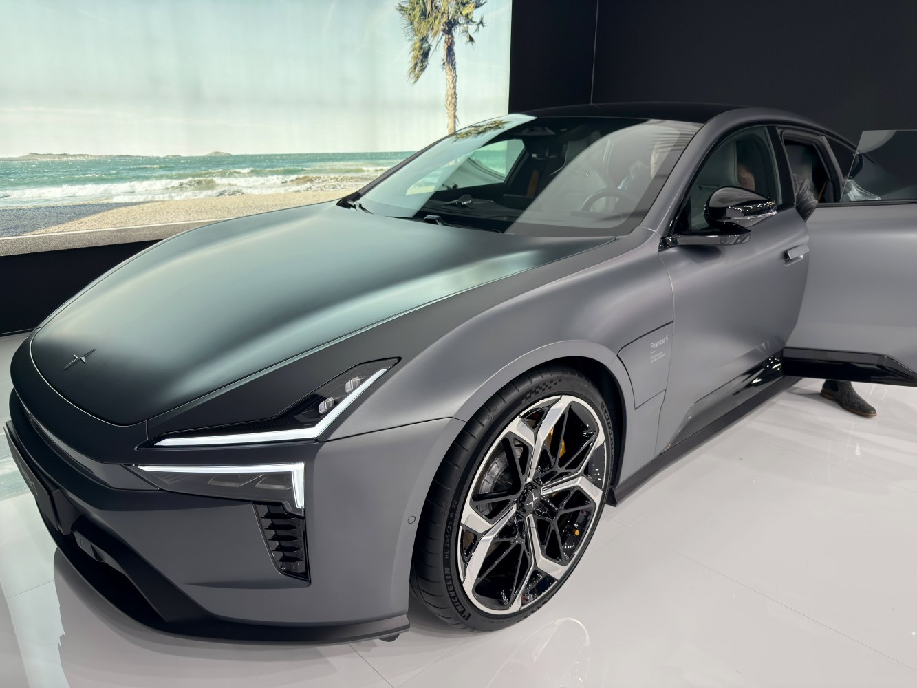 Sleek electric sedan front with futuristic LED headlights and alloy wheels.