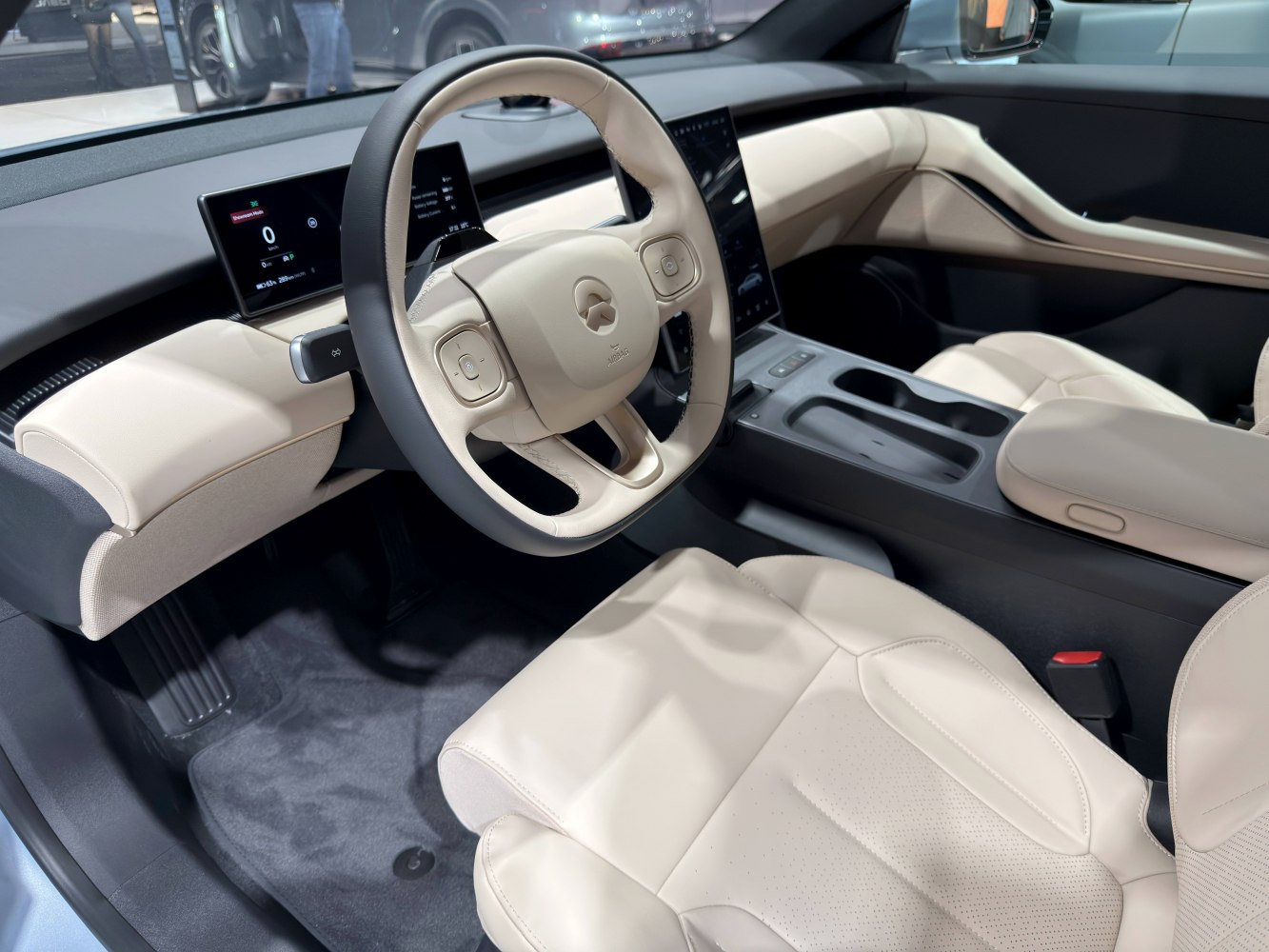 Beige leather seats and digital displays inside a modern car interior