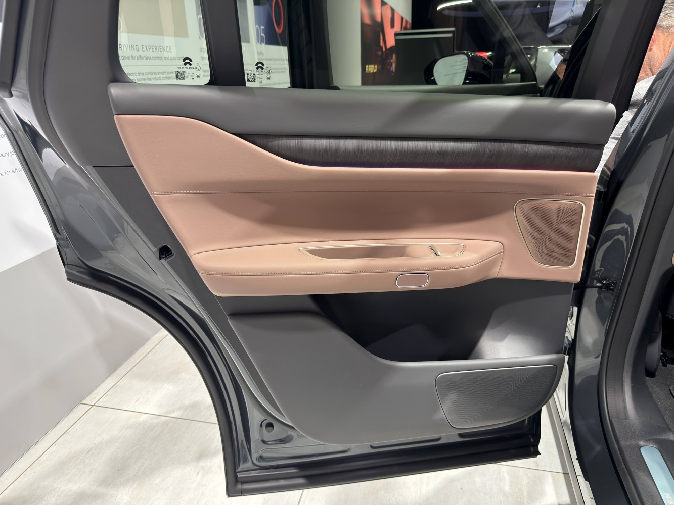 Luxurious rear door panel with integrated speaker, handle, and soft-touch materials.