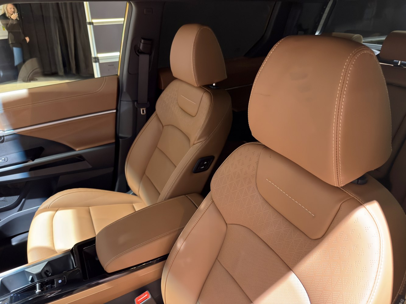 Tan leather ergonomic car seats with detailed stitching