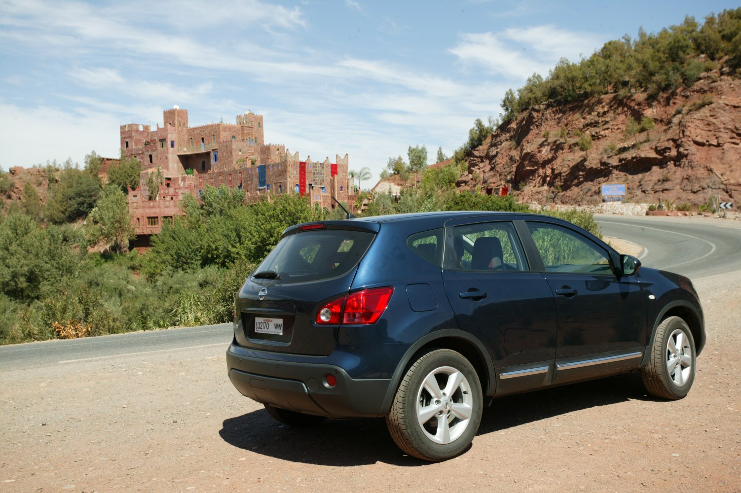 Rear and side profile of an SUV parked on roadside with natural background
