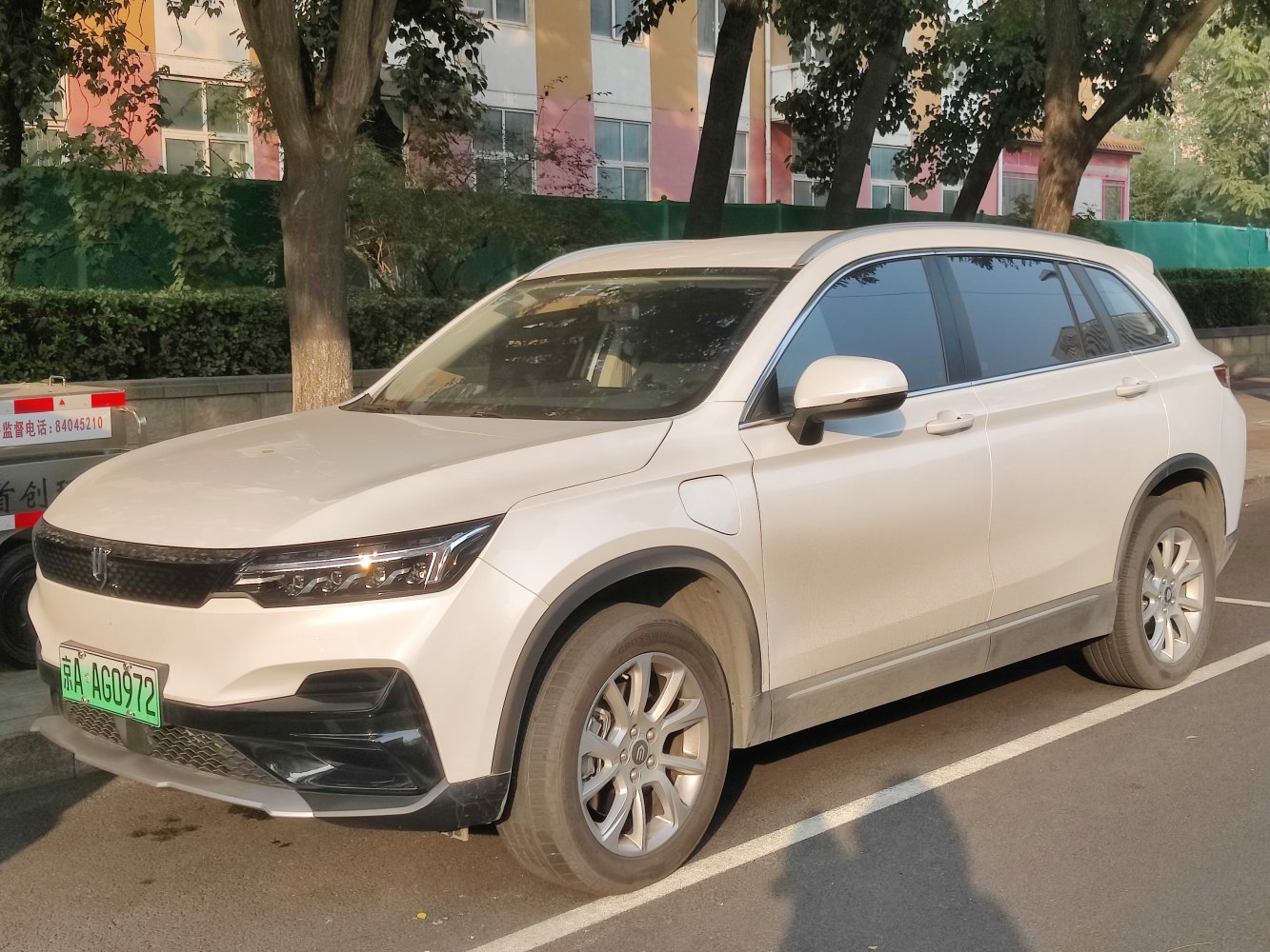 Front side view of an electric SUV with sleek headlights and charging port