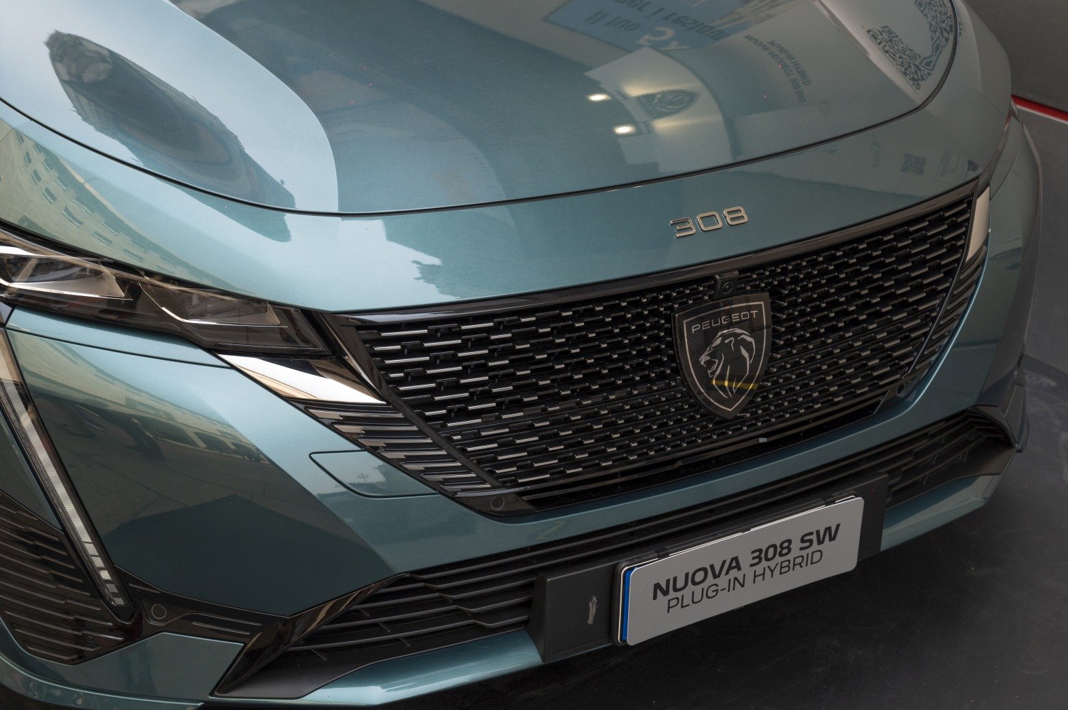 Close-up of front grille and headlight with Peugeot emblem