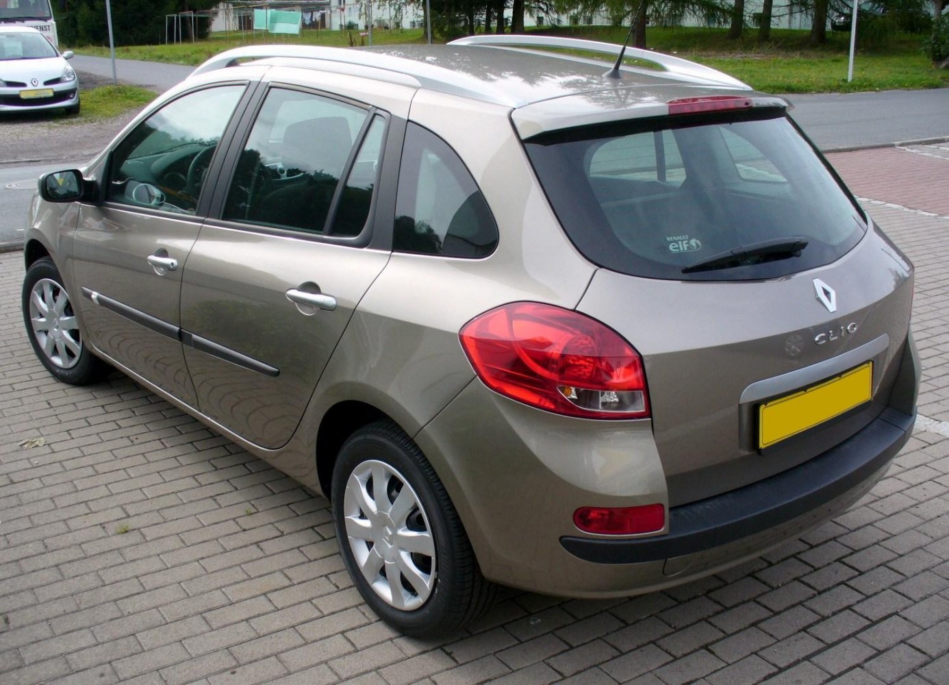 Compact station wagon rear-side with roof bars and distinctive tail lights