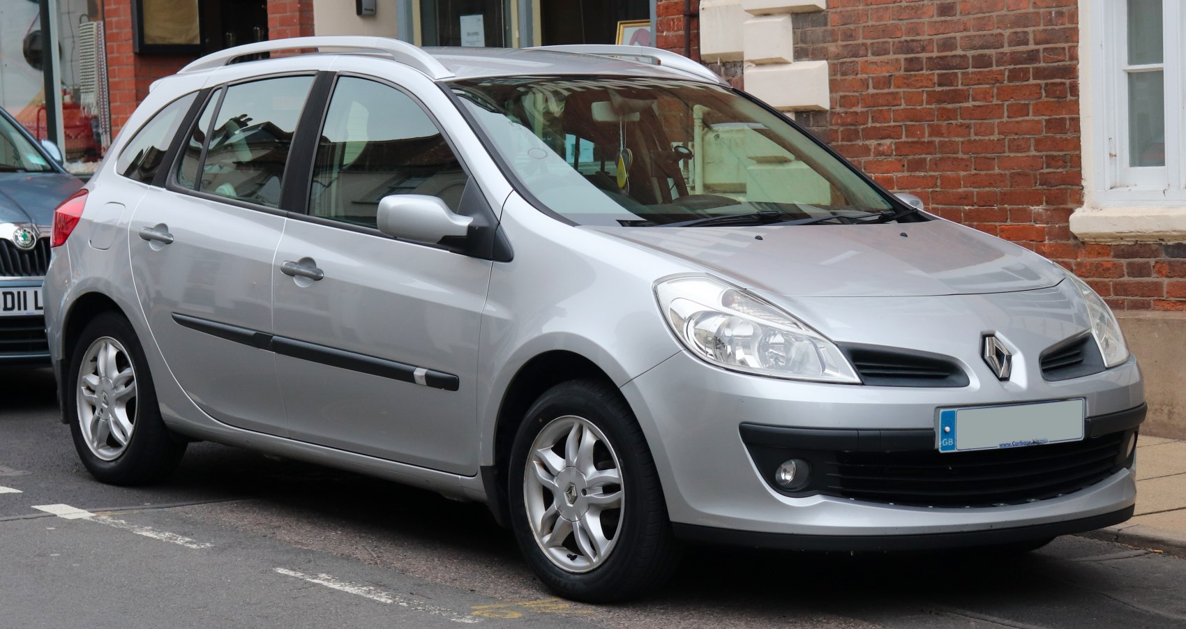 Front side view of compact silver hatchback with roof rails and alloy wheels