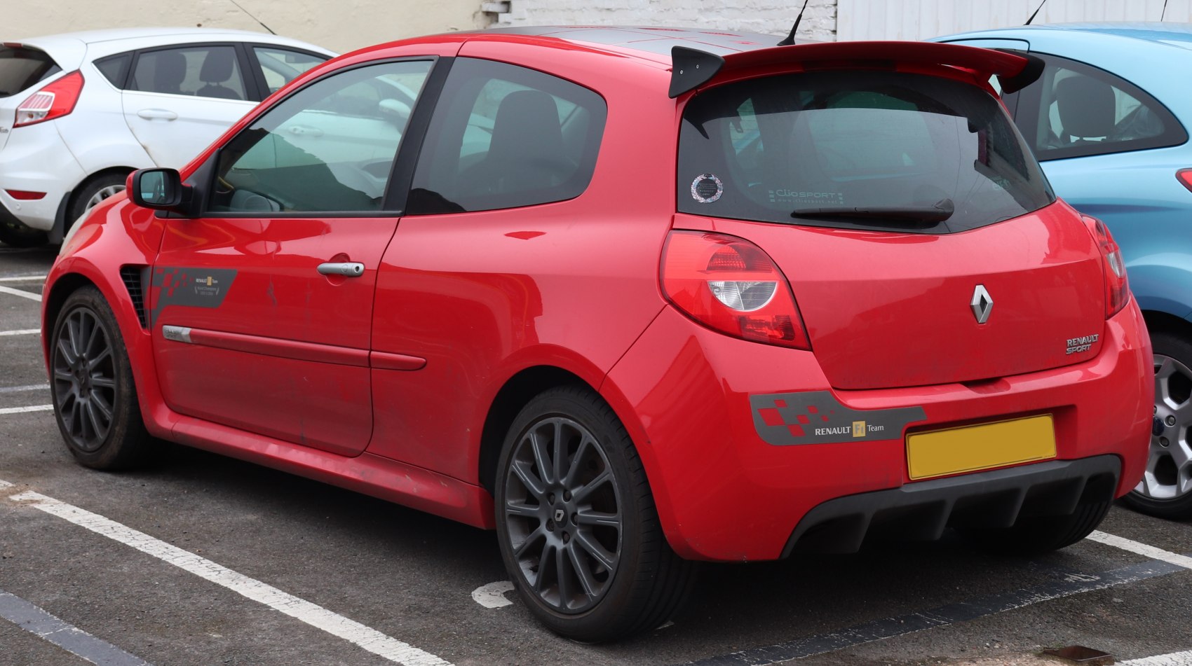 Red 3-door hatchback with rear spoiler and dark alloy wheels