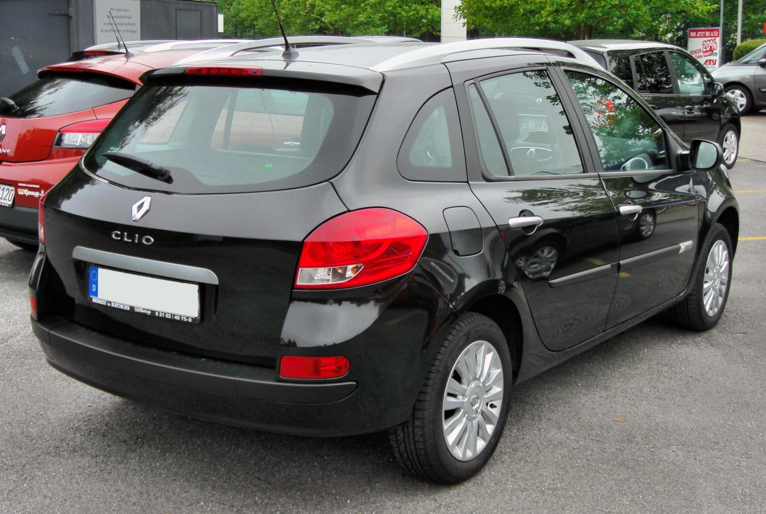 Rear-side of black hatchback with roof rails and distinctive taillights