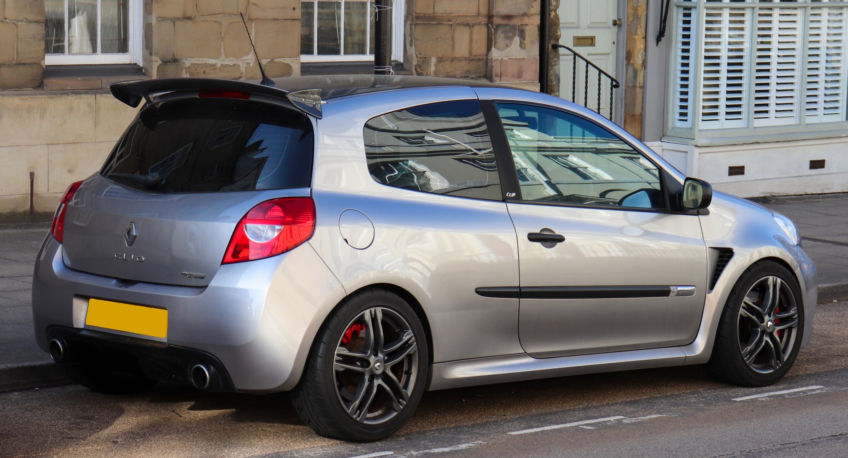 Rear side view of sporty 3-door hatchback with dual exhausts and alloy wheels