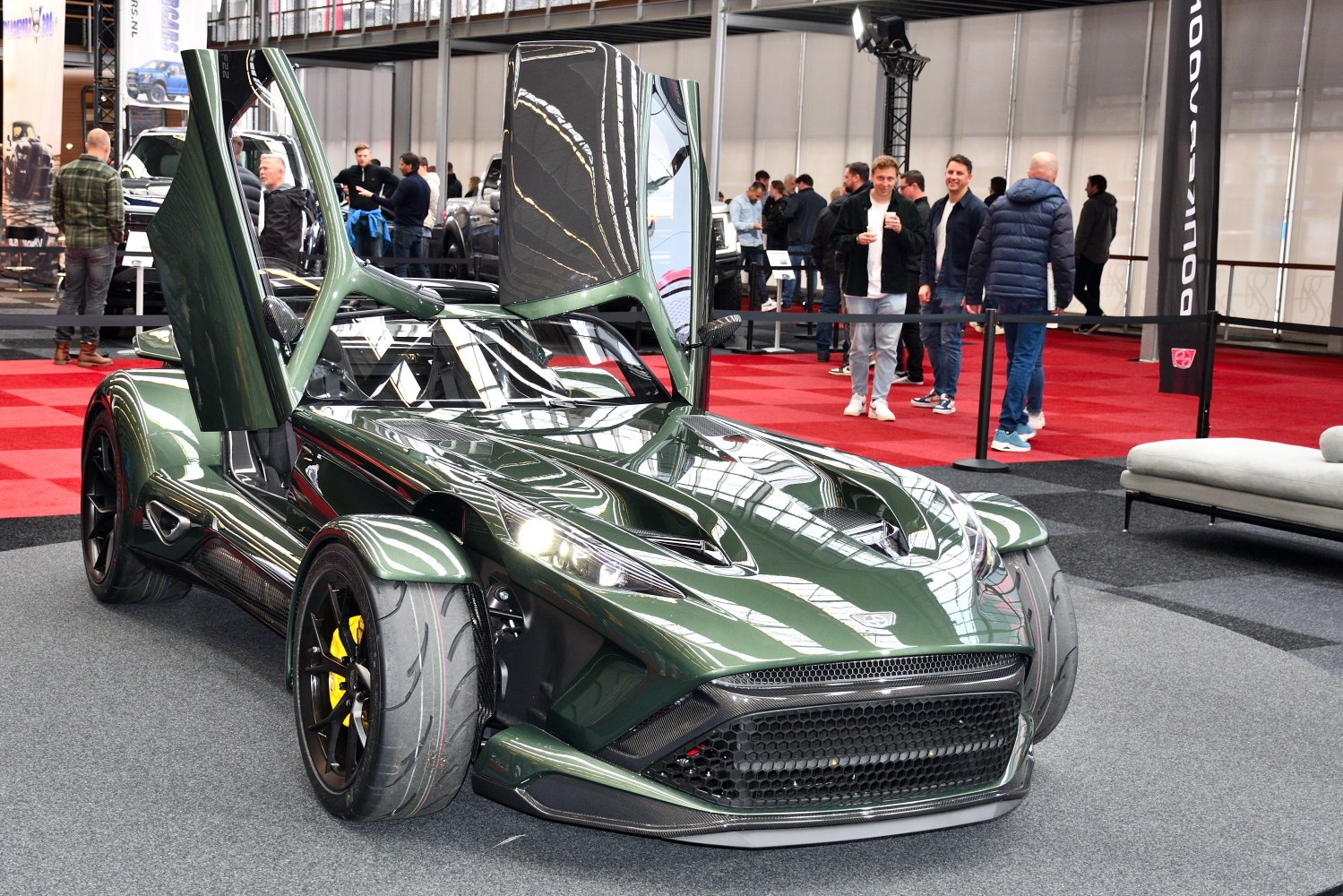 Scissor doors and aggressive front grille on a sleek sports vehicle