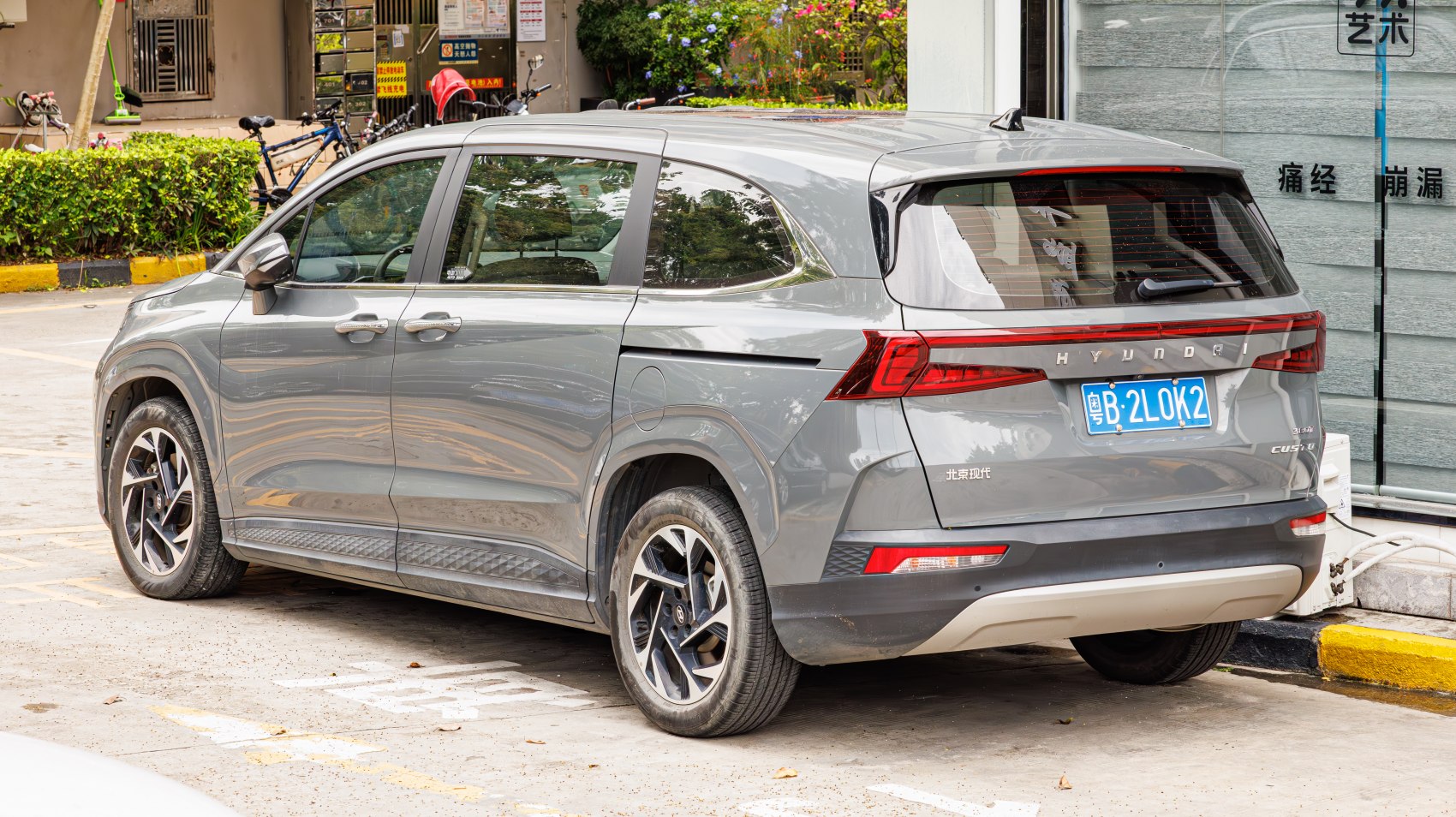 Rear and side profile of a grey mid-size SUV with sleek design and alloy wheels