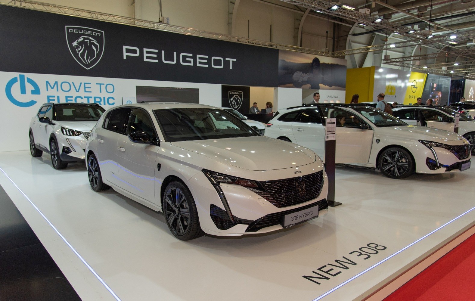 Front and side view of a white hybrid hatchback with modern LED headlights and alloy wheels