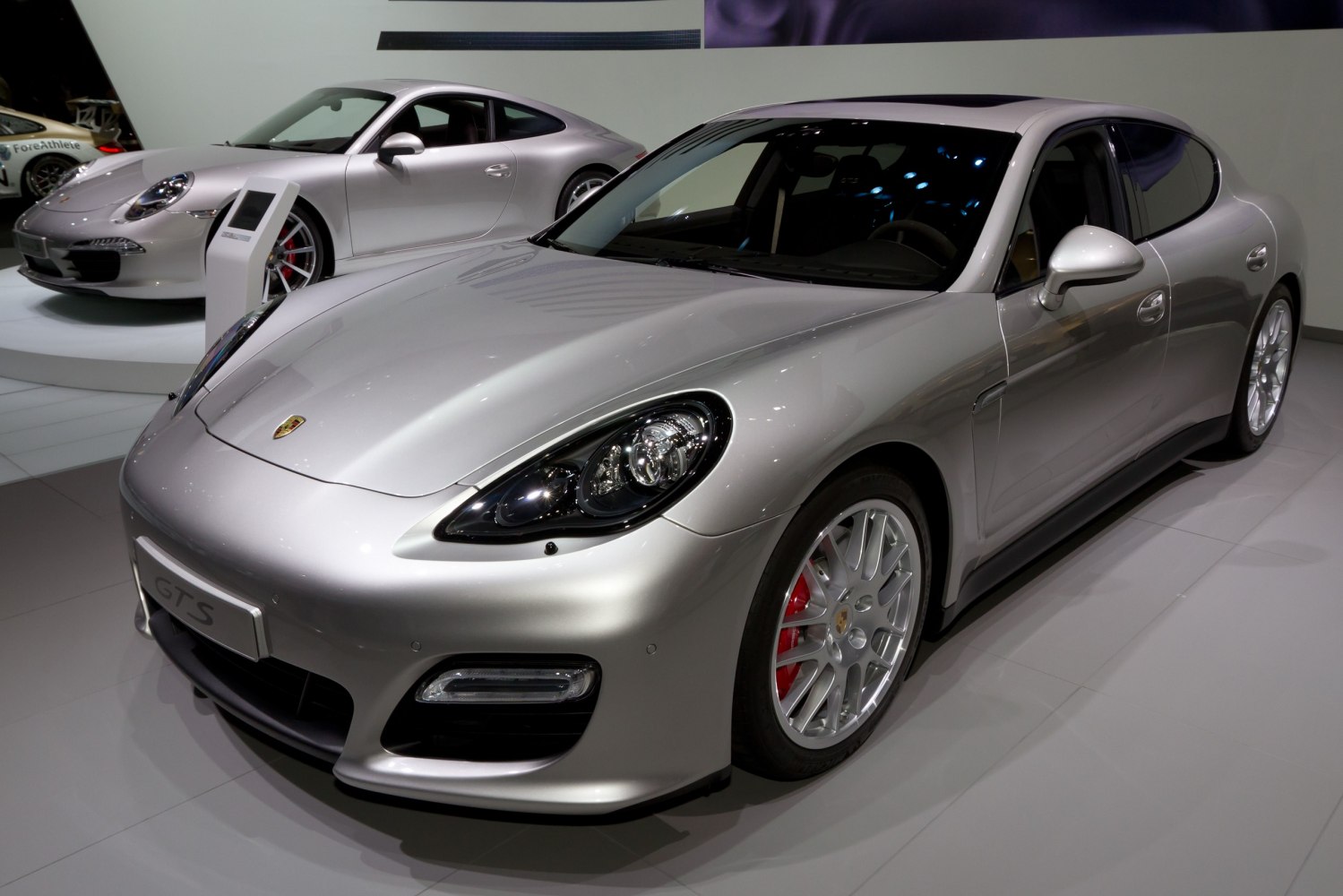 Front-side view of silver luxury sedan with distinctive headlights and sporty wheels