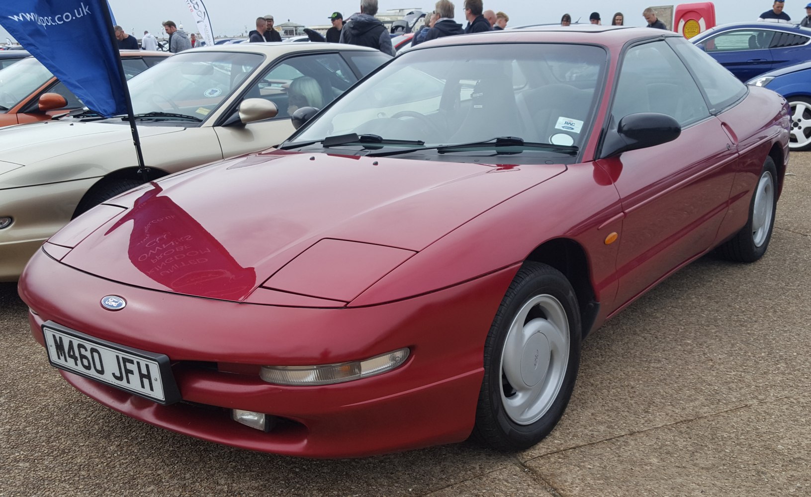 Red 1990s coupe with pop-up headlights and sleek aerodynamic shape